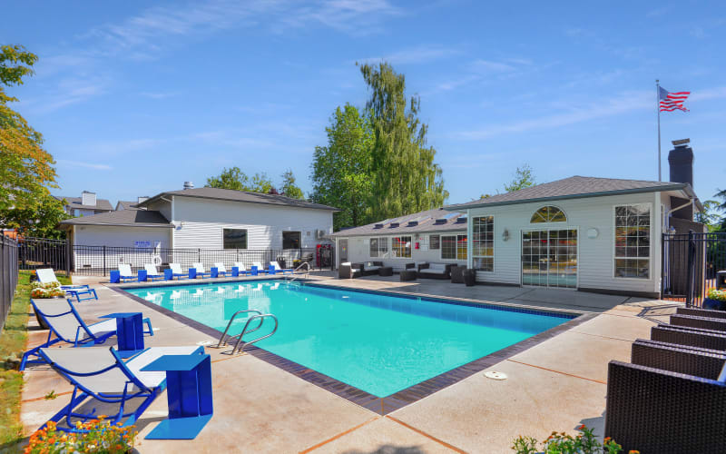 Seating near the swimming pool on a sunny day at Wellington Apartment Homes in Silverdale, Washington