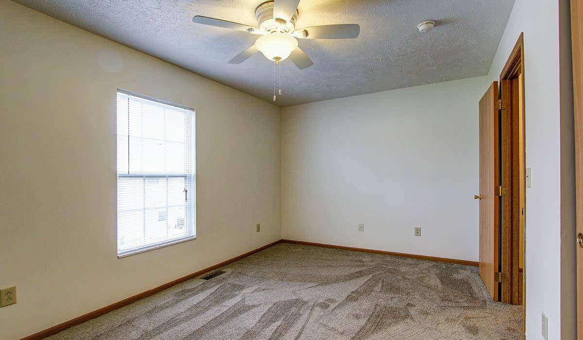 Carpeted room with ceiling fan and window at Wellington Place in Ottawa, Ohio
