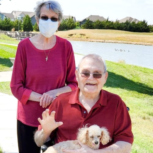 Resident couple out for a walk with their dog at The Oxford Grand Assisted Living & Memory Care in Wichita, Kansas