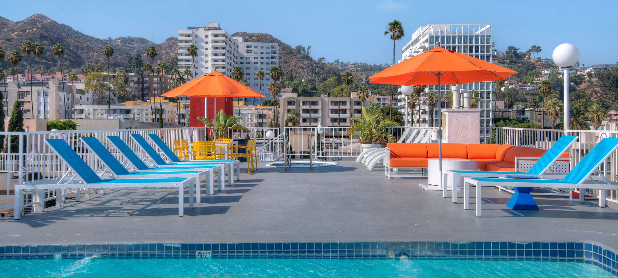 Luxurious pool side patio with sun chairs at The Jessica Apartments, Los Angeles, California