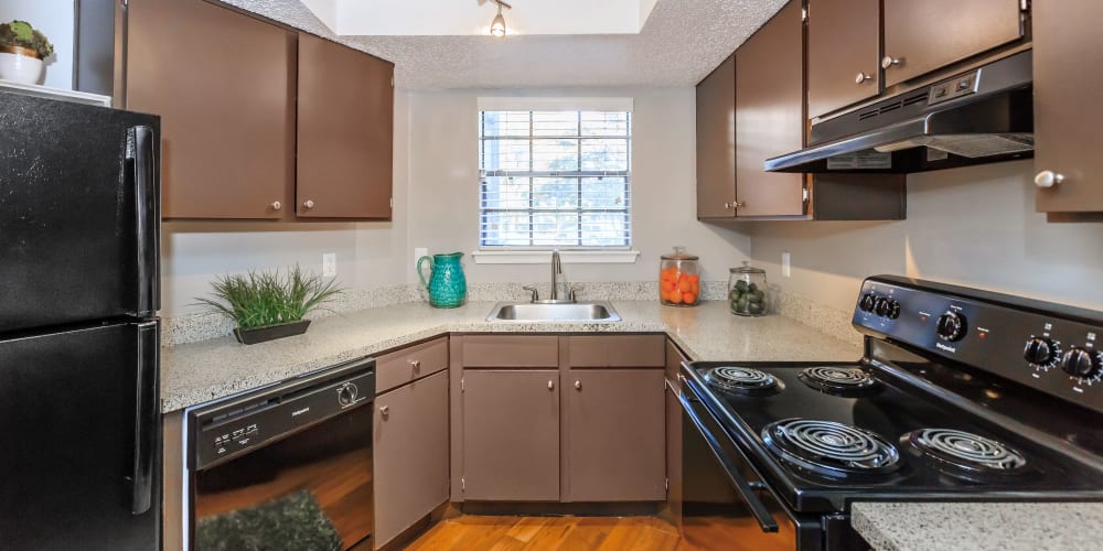 Kitchen with black appliances at Tides at Highland Meadows in Dallas, Texas