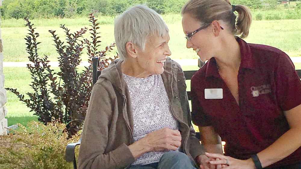 caretaker and resident chatting at Oxford Glen Memory Care at Carrollton in Carrollton, Texas