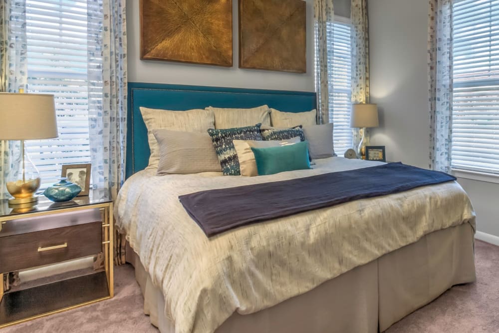 Model home's master bedroom with a ceiling fan and plush carpeting at The Palmer in Charlotte, North Carolina