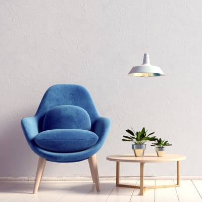 Plants on an end table next to a blue velvet chair at Sofi Union City in Union City, California