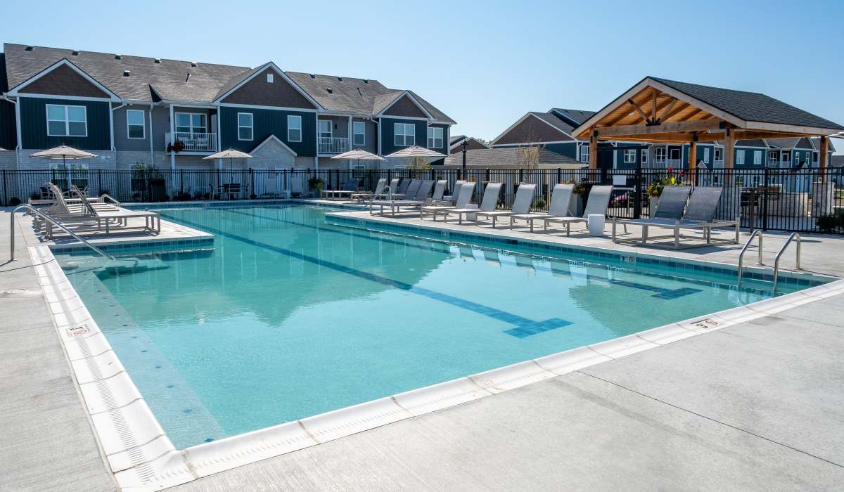 Pool with umbrellas and loungers at Remington Lake Apartments in Hamilton, Ohio