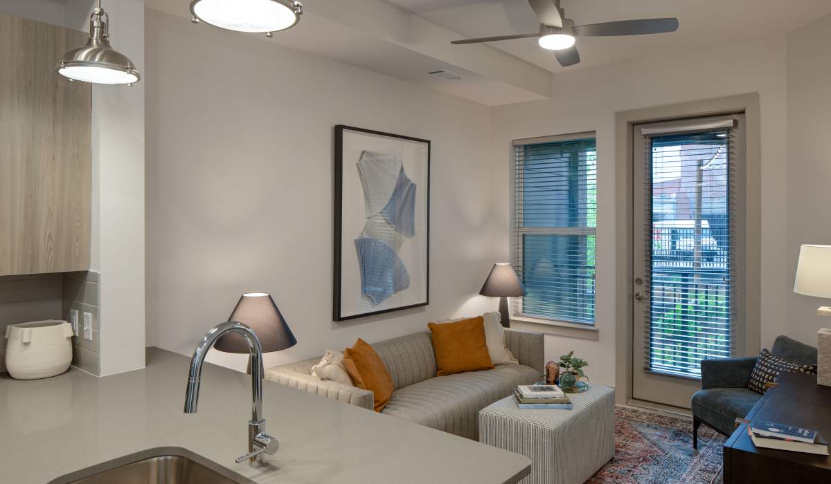 Living room with a door out to a private balcony at Venable Durham Apartments in Durham, North Carolina