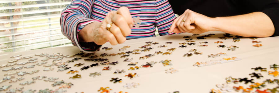 Resident having fun working on a puzzle at Ingleside Communities in Mount Horeb, Wisconsin