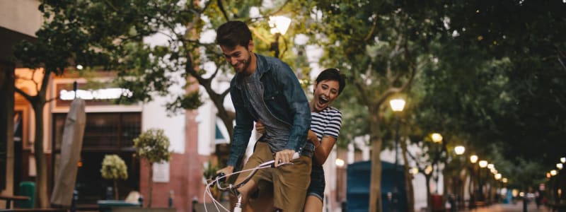 Residents riding a bike in Austin, Texas near Regents West at 26th