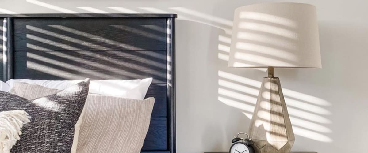 Serene bedroom with bed and nightstand at The Gateway Apartments in Mobile, Alabama