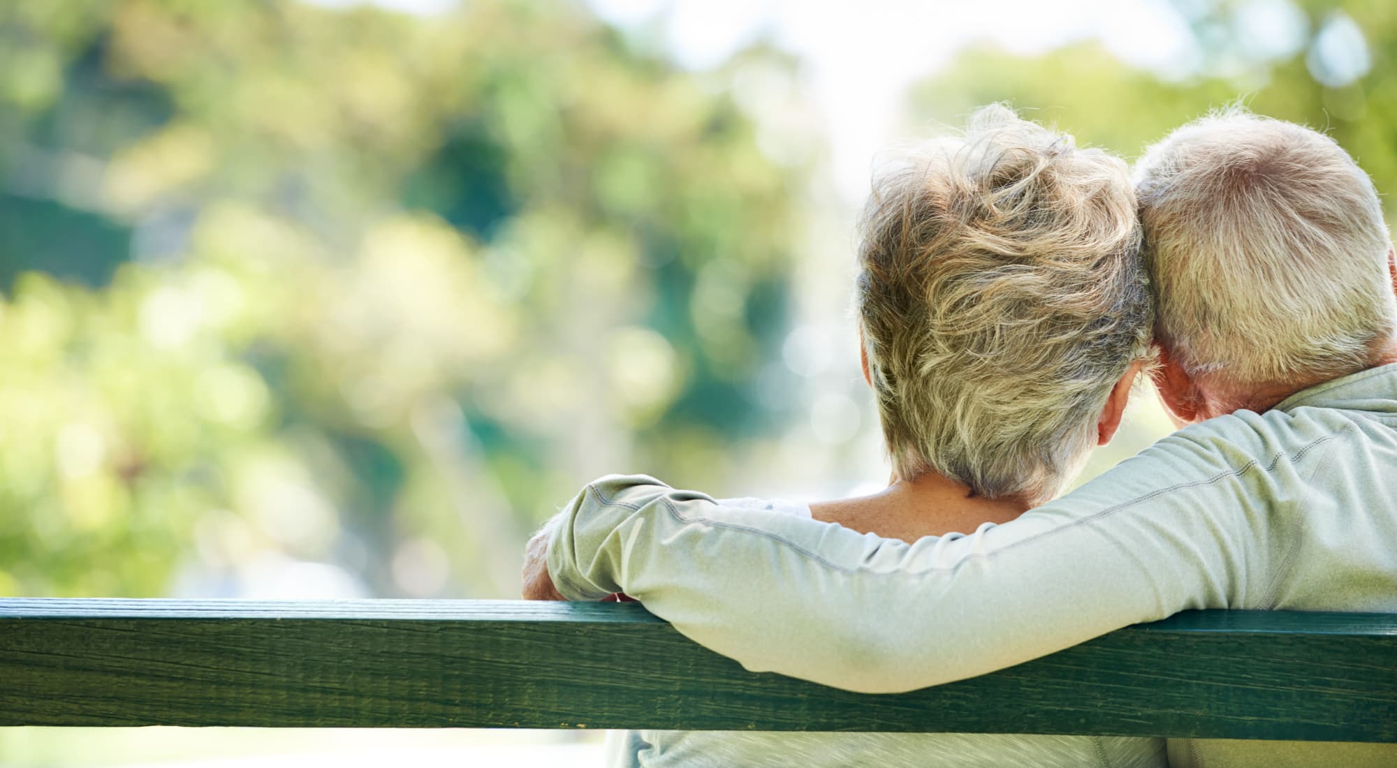 Two senior living residents resting on a bench near Maplewood Senior Living