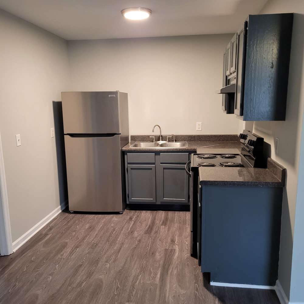 A kitchen with refrigerator, water faucet sink and cabinetry at Maple Manor Apartments in Lebanon, Tennessee