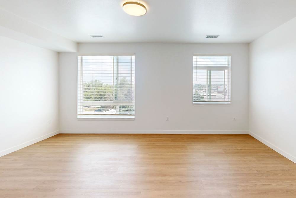 Spacious living room with a large window and wood-style flooring at The Rose on Colfax in Denver,Colorado