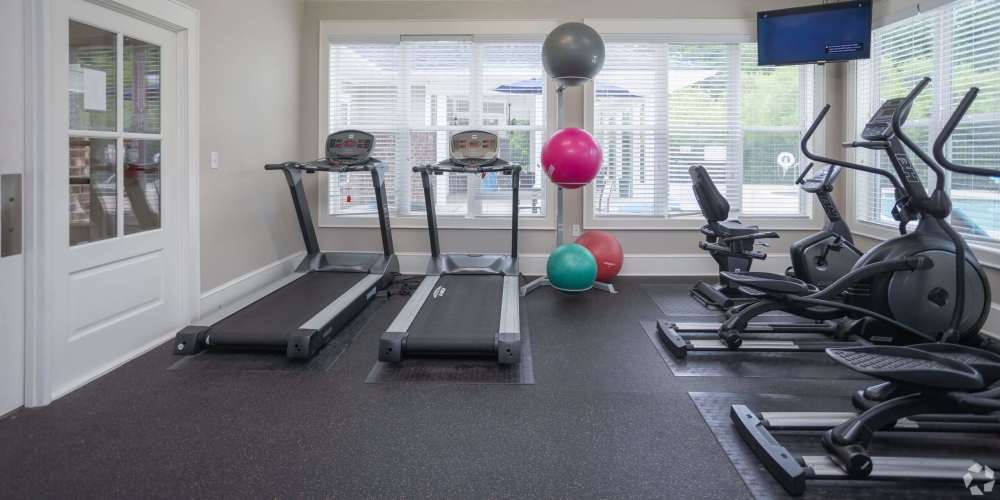 Fitness center with treadmills and windows at Seasons at Poplar Tent in Concord, North Carolina