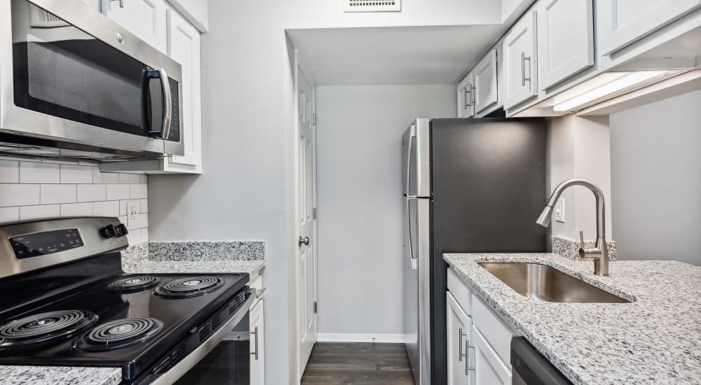 Granite countertops and black appliances in an apartment kitchen at Park West End in Richmond, Virginia