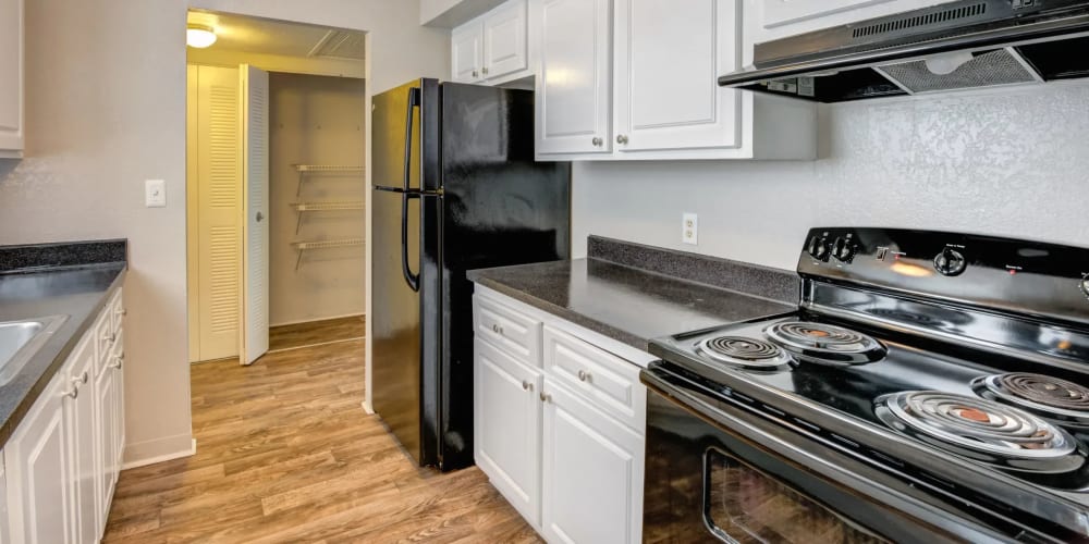 Apartment kitchen with black appliances and white cupboards at Costa Del Lago in Lake Worth, Florida