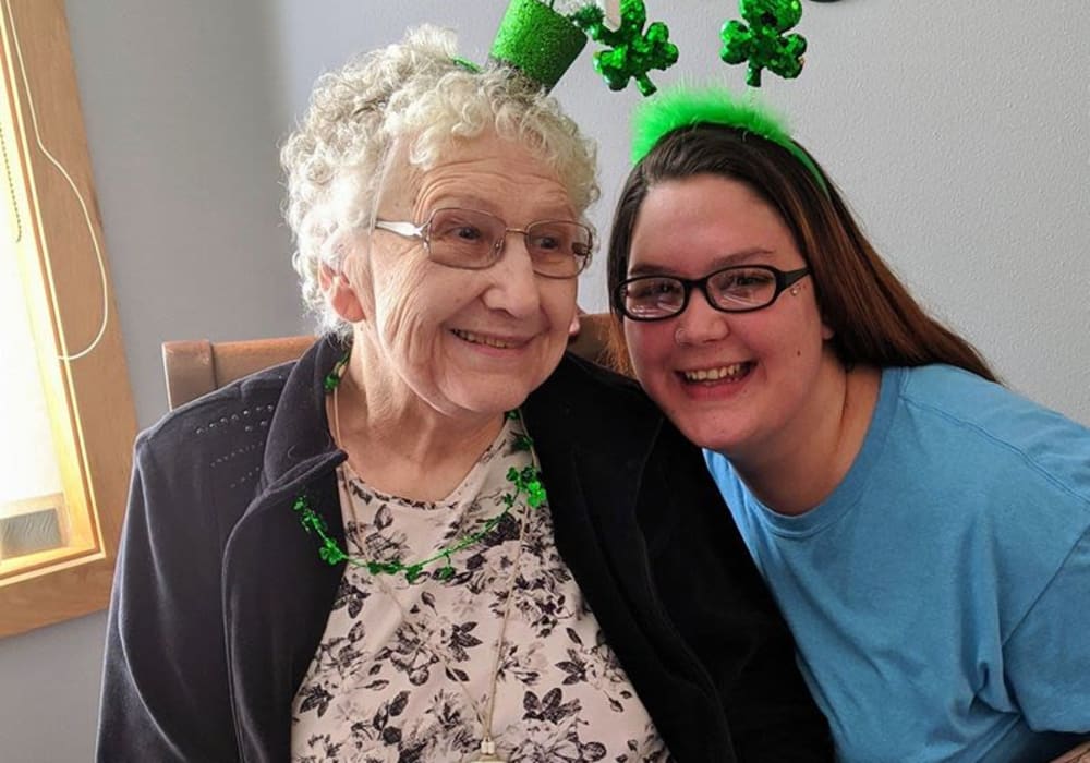 Resident and caregiver celebrating Saint Patrick's Day at Wellington Place at Hartford in Hartford, Wisconsin