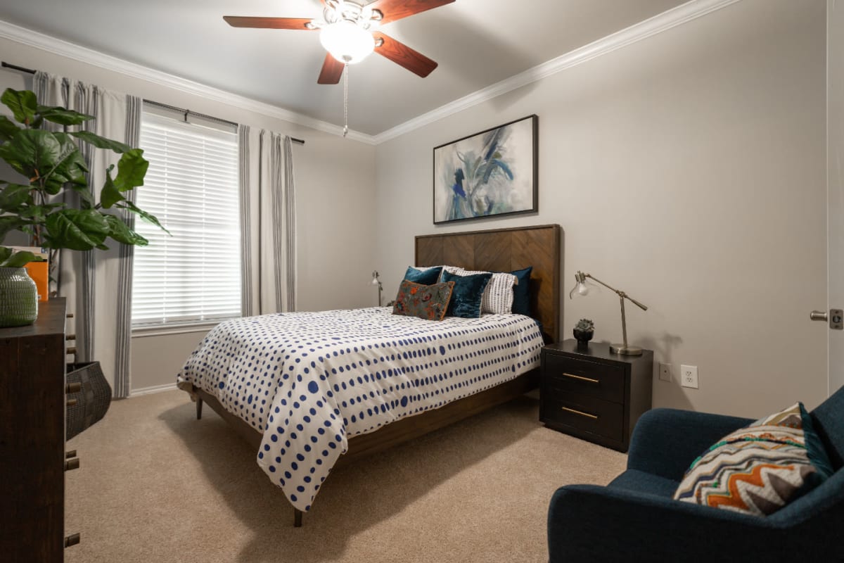 Carpeted bedroom with ceiling fan at Marquis at Bellaire Ranch in Fort Worth, Texas
