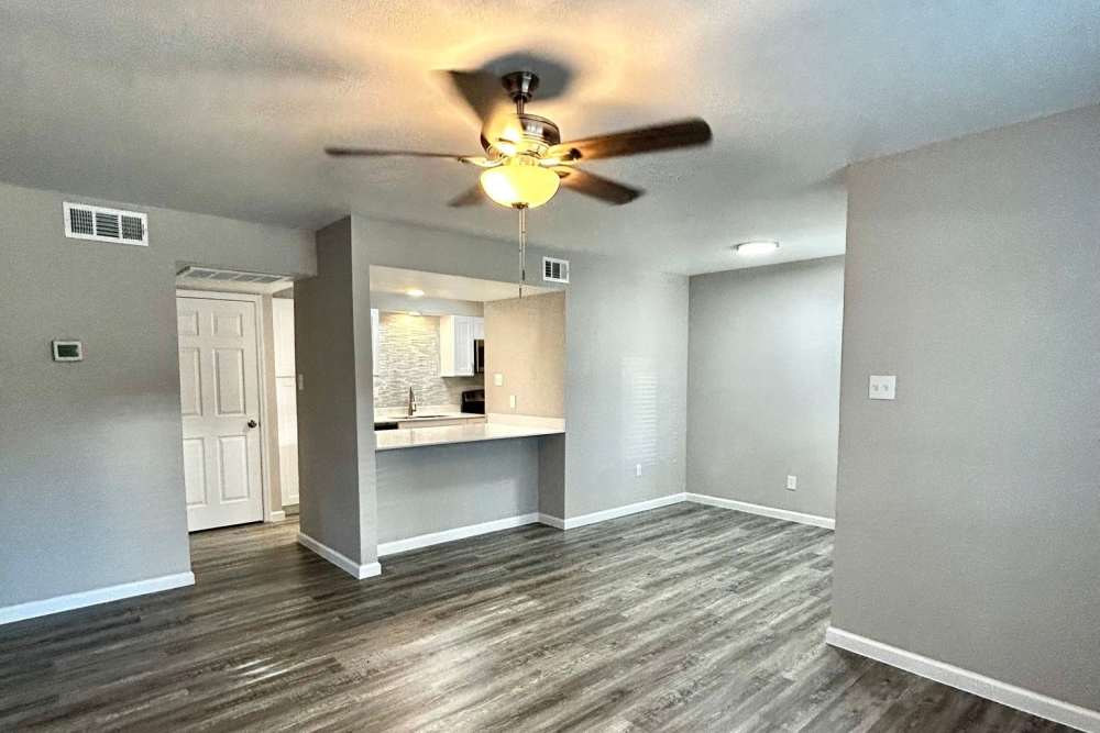 View of fully equipped kitchen and spacious living area with ceiling fan at Athena Garden Apartments in Athens, Texas