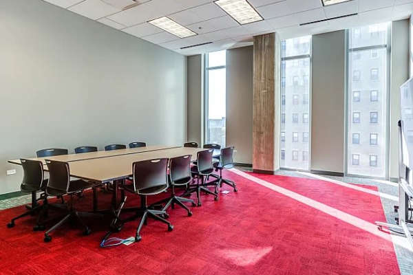 A modern conference room featuring a large table at The Flats at East West University in Chicago, Illinois