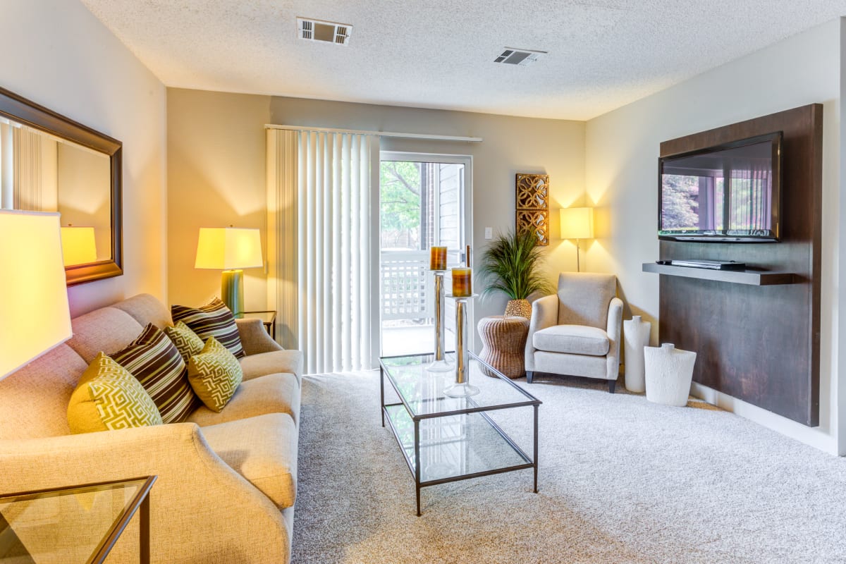 Living room opening onto a private patio at The Lakes of Schaumburg Apartment Homes in Schaumburg, Illinois