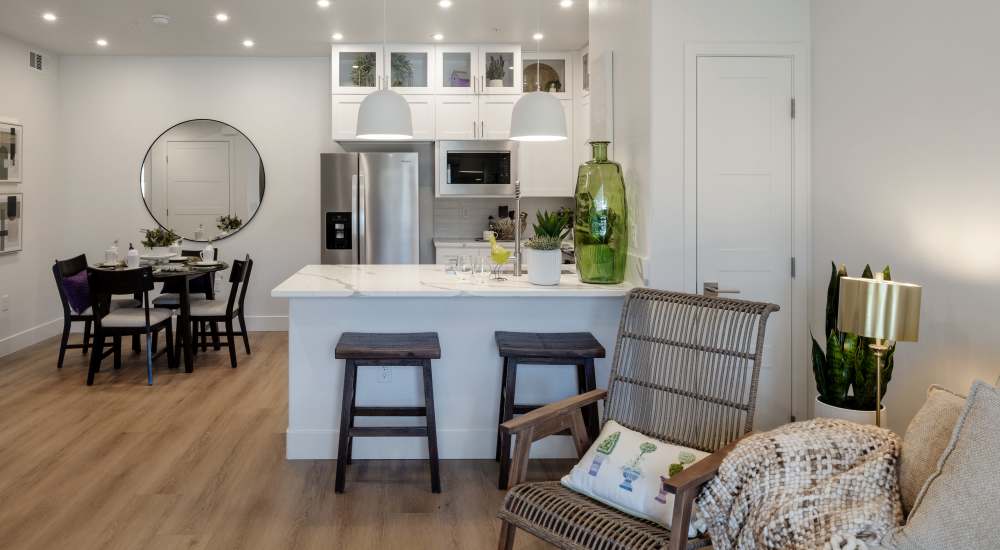 Kitchen with white cabinets, island and bar stools at Continuum Apartments in Las Vegas, Nevada
