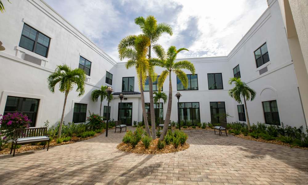 Apartment exterior shot with benches at Keystone Place at Beachwalk in Fort Myers, Florida