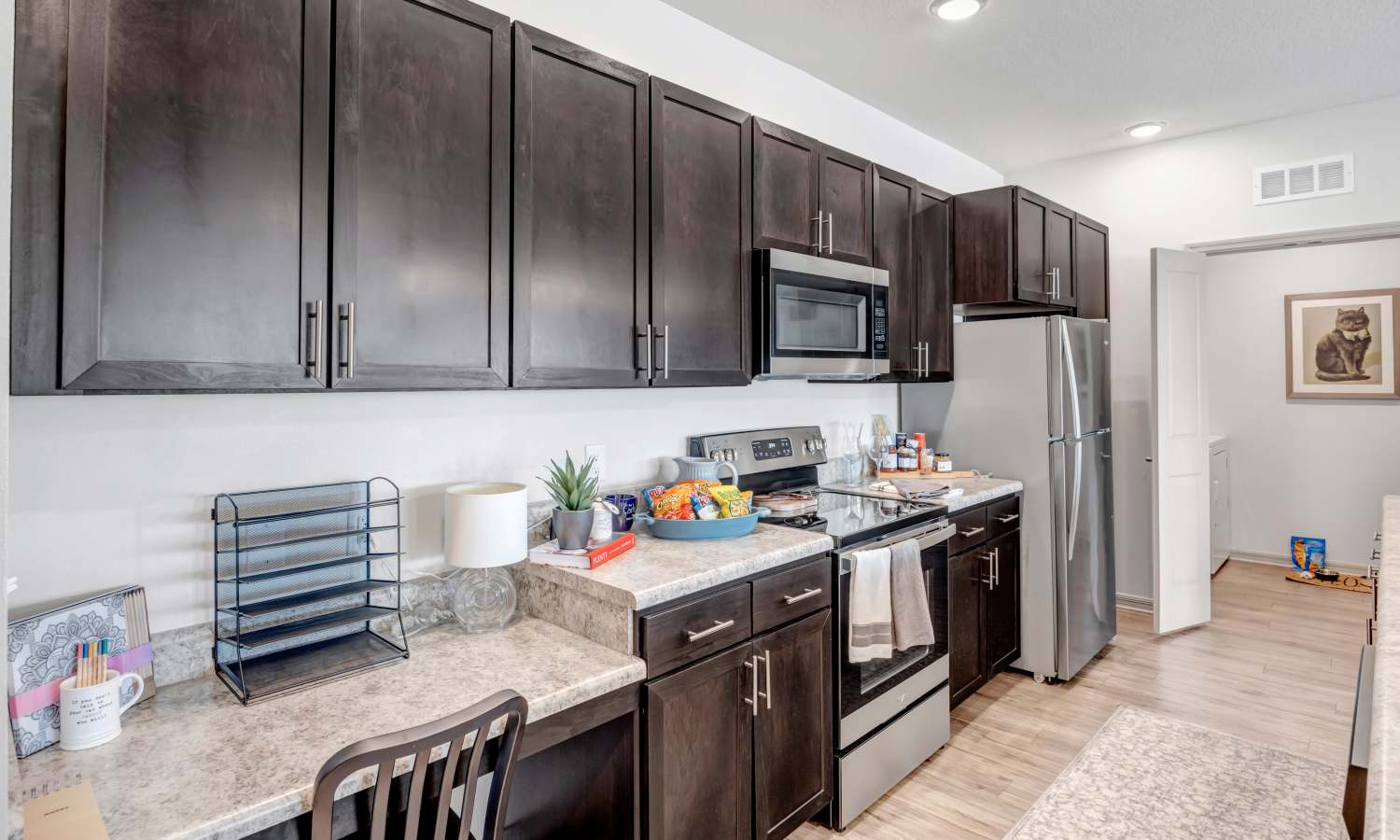 Apartment kitchen with appliances and wooden cabinets at The Carlton of Fort Myers in Fort Myers, Florida