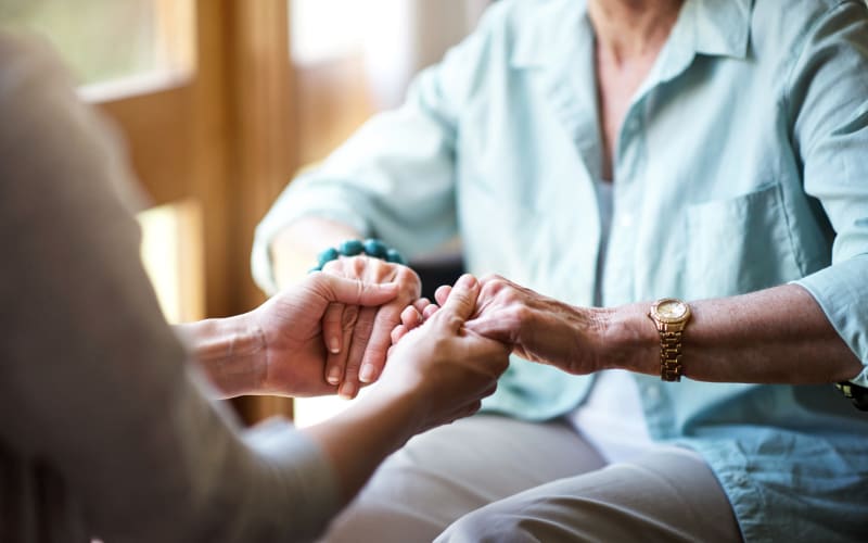 Caregiver holding her father's hands at Grand Villa of Boynton Beach in Boynton Beach, Florida