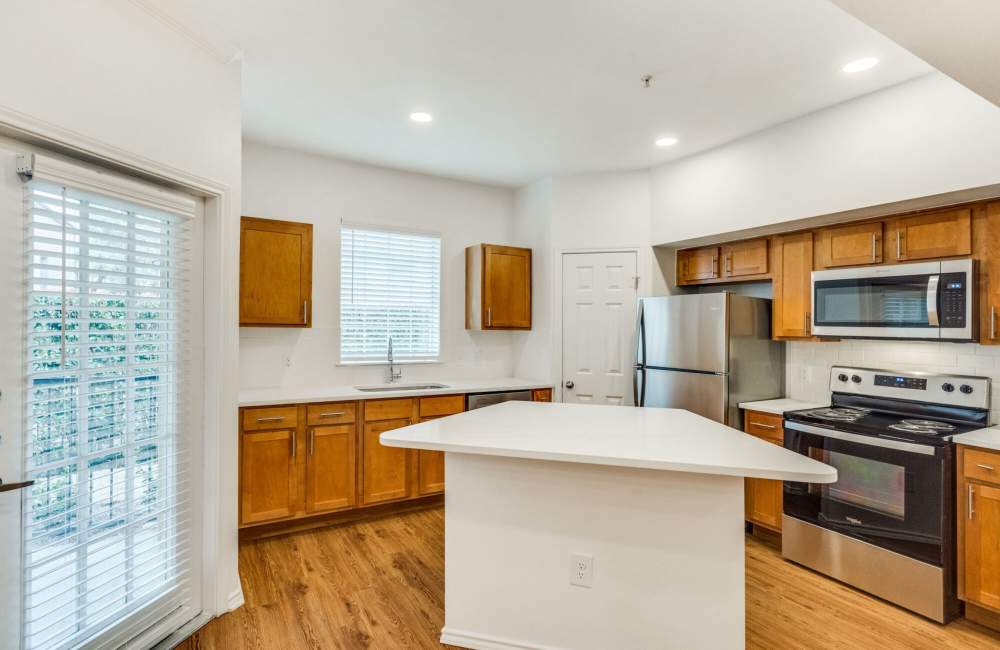 Well-equipped kitchen with wooden flooring at Spicewood Crossing in Carrollton, Texas
