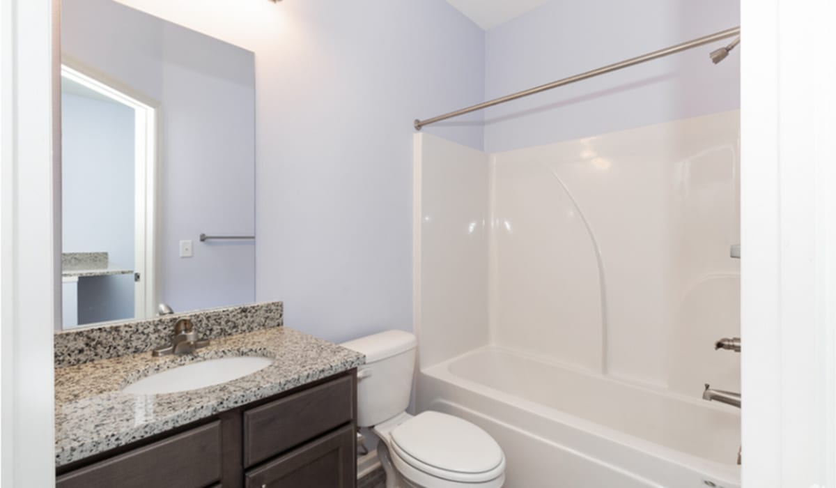 Bright bathroom with vanity light, mirror, sink, commode and standard bathtub at Las Colinas in Foley, Alabama