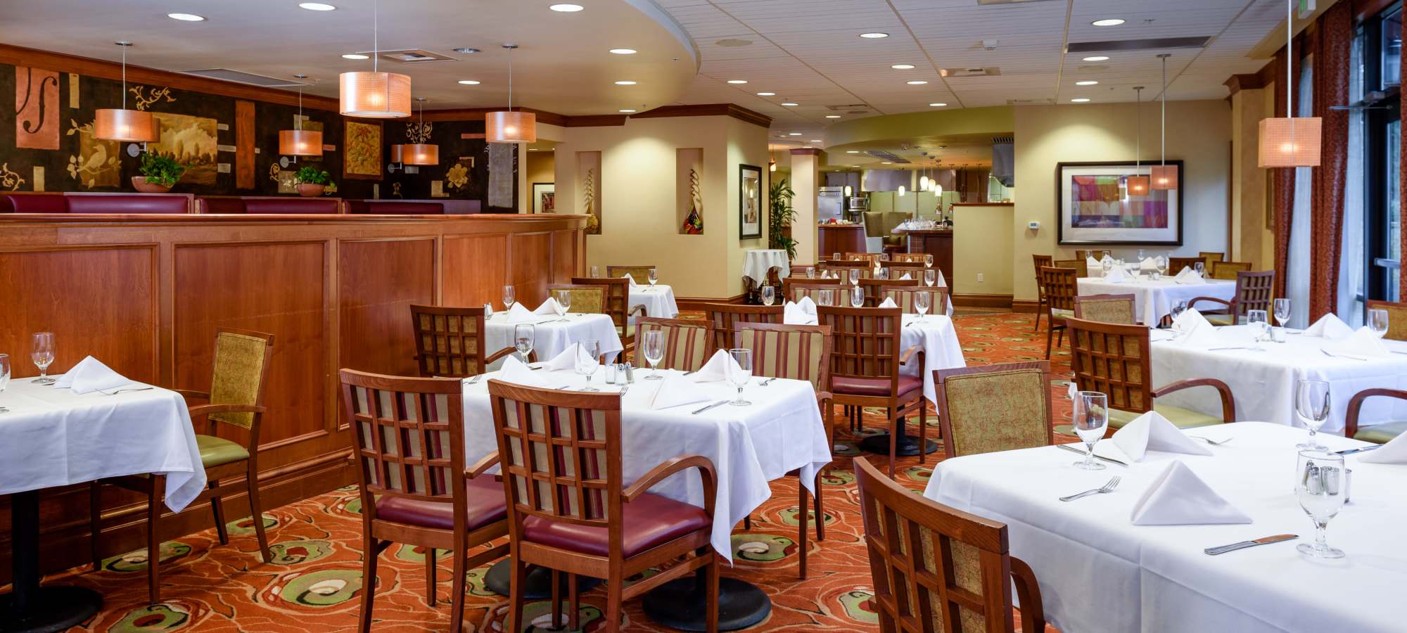 Restaurant dining room with set tables, warm lighting at The Bellettini in Bellevue, Washington
