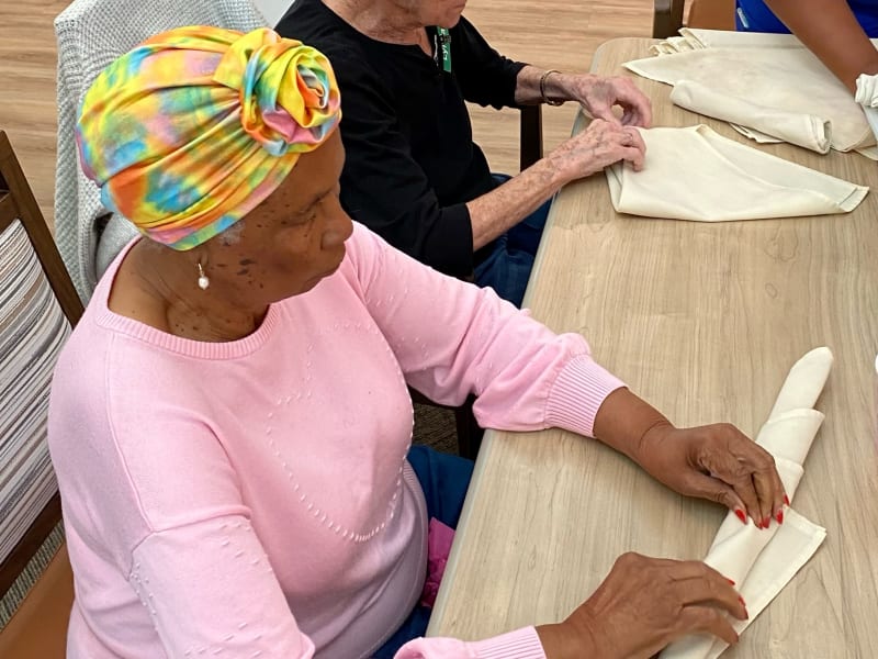 Resident folding napkins at The Village at Summerville in Summerville, South Carolina