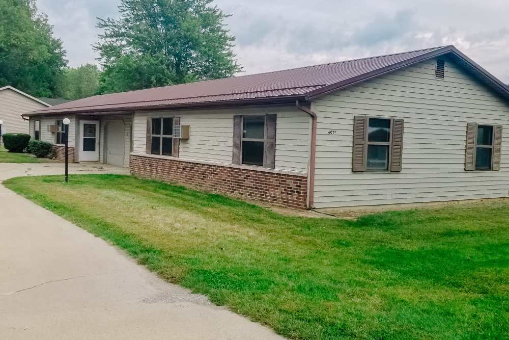 Exterior of the apartment with lawn at West Unity Apartments in West Unity, Ohio