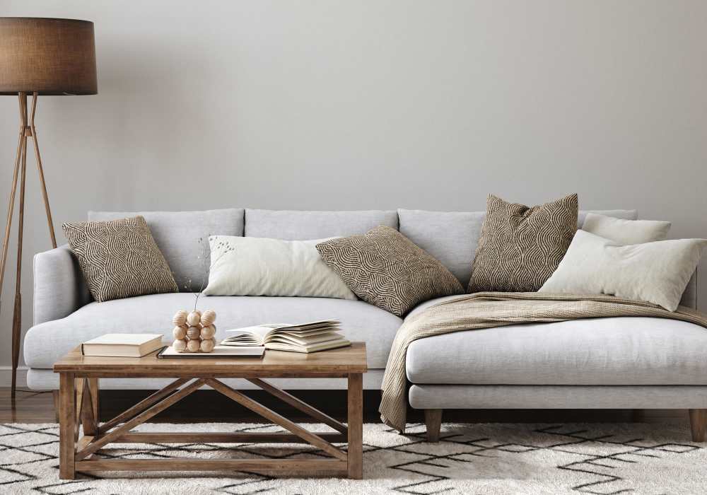 Living room with large couch, coffee table, side table lamp and wood-style flooring at Crystal Commons Townhomes in Gates, New York