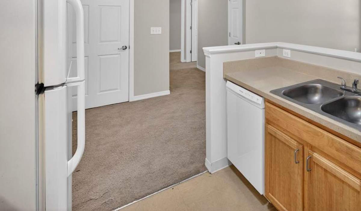 Kitchen with white appliances including dishwasher at Crowfield Greene in Goose Creek, South Carolina