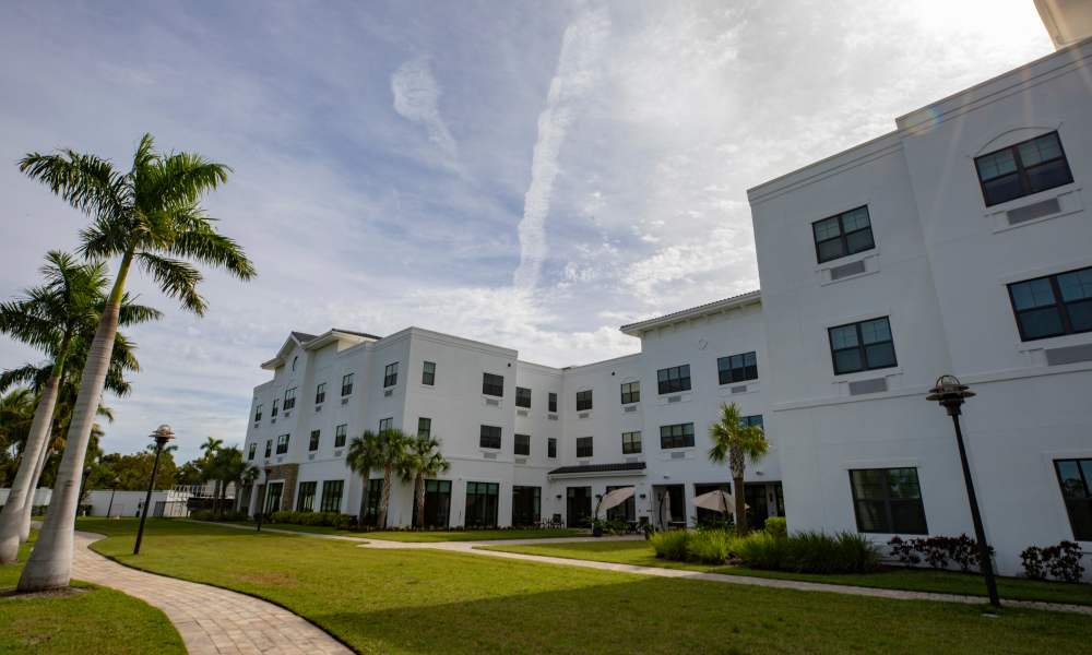 Exterior rendering of apartments with beautiful walkway at Keystone Place at Beachwalk in Fort Myers, Florida