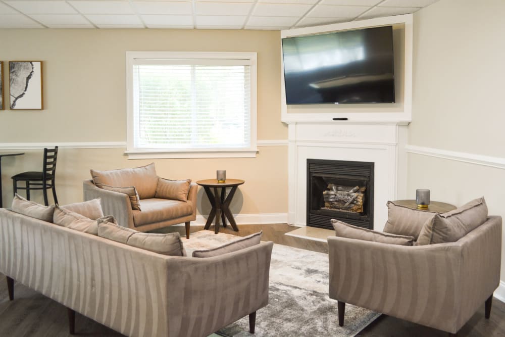 Living room with a fireplace and wall mounted tv at The Village at Voorhees in Voorhees, New Jersey