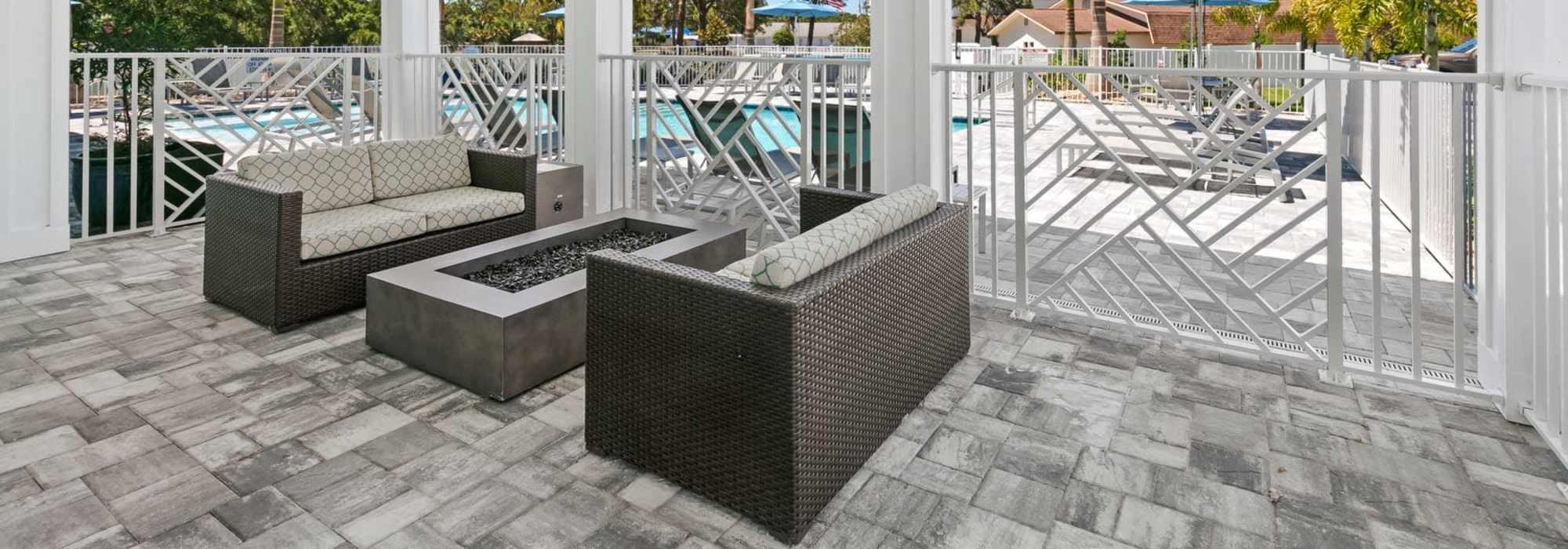 Charming outdoor lounge area with stylish seating and a modern fire feature at Lemon Bay Apartments in Englewood, Florida.