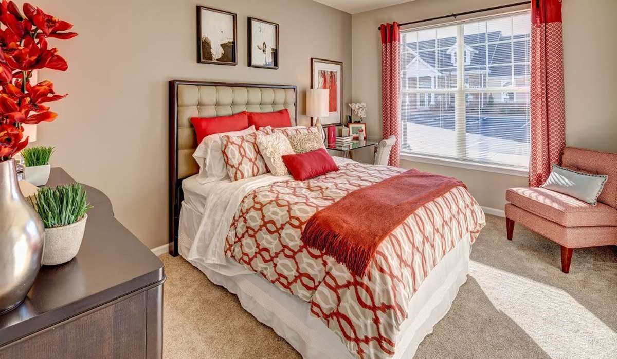 Bedroom with red linens at Alterra | Rocky Hill in Rocky Hill, Connecticut