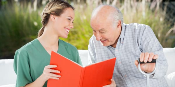 Resident and caretaker reading outside at Holton Manor in Elkhorn, Wisconsin