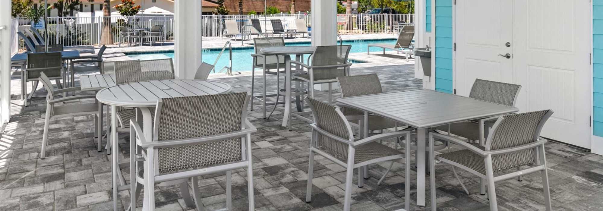 Inviting outdoor lounge area with stylish seating and a sparkling water pool at Lemon Bay Apartments in Englewood, Florida.