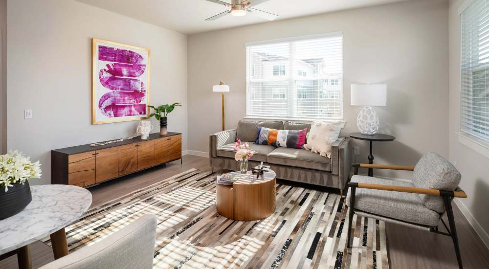 Living room with modern decor and natural light at August Friendswood in Friendswood, Texas