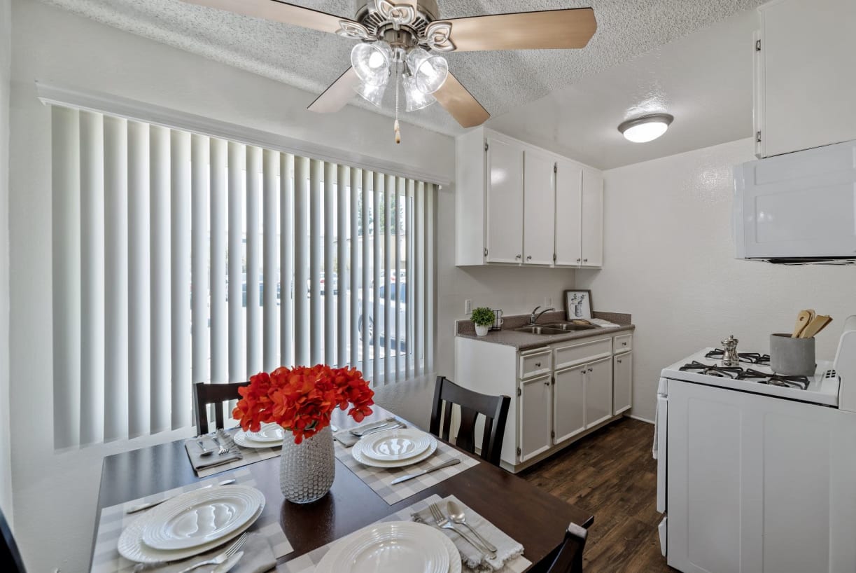 Dining room and kitchen with gas range and plank flooring The Newporter in Tarzana, California