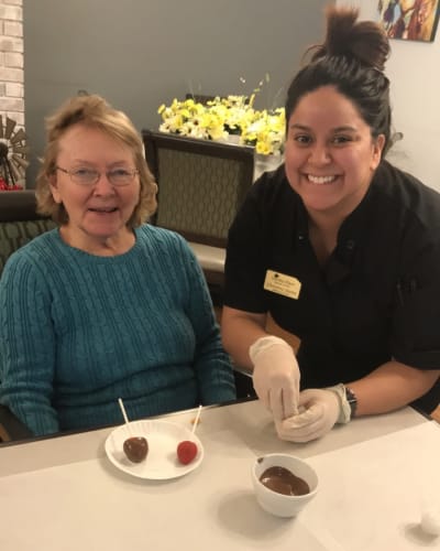 Staff member helping a resident make dessert at Reflections at Garden Place in Columbia, Illinois.