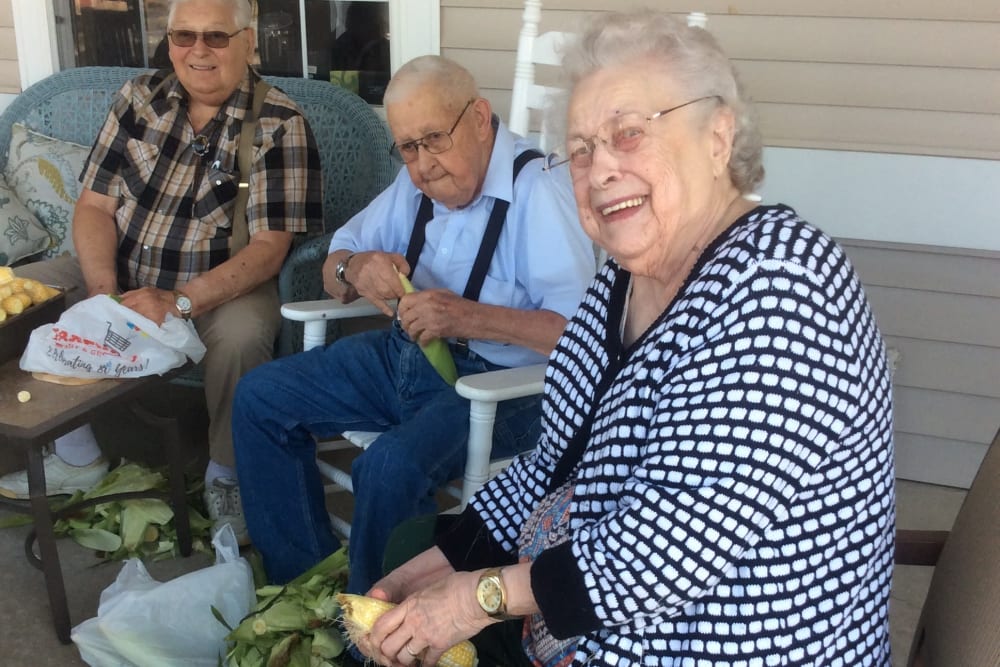 Residents shuck corn on the porch at Clover Ridge Place in Maquoketa, Iowa.