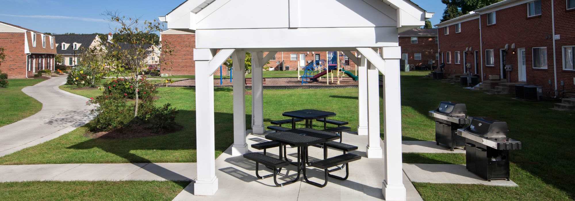 Community park with lots of grass, tables and barbecues at The Landing at Oyster Point in Newport News, Virginia