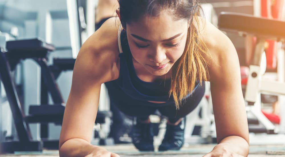 Woman holding a plank at the fitness center at Crystal Springs in Fort Worth, Texas