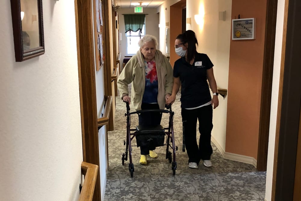 Staff provides assistance to resident with walker at Landings of Sauk Rapids in Sauk Rapids, Minnesota