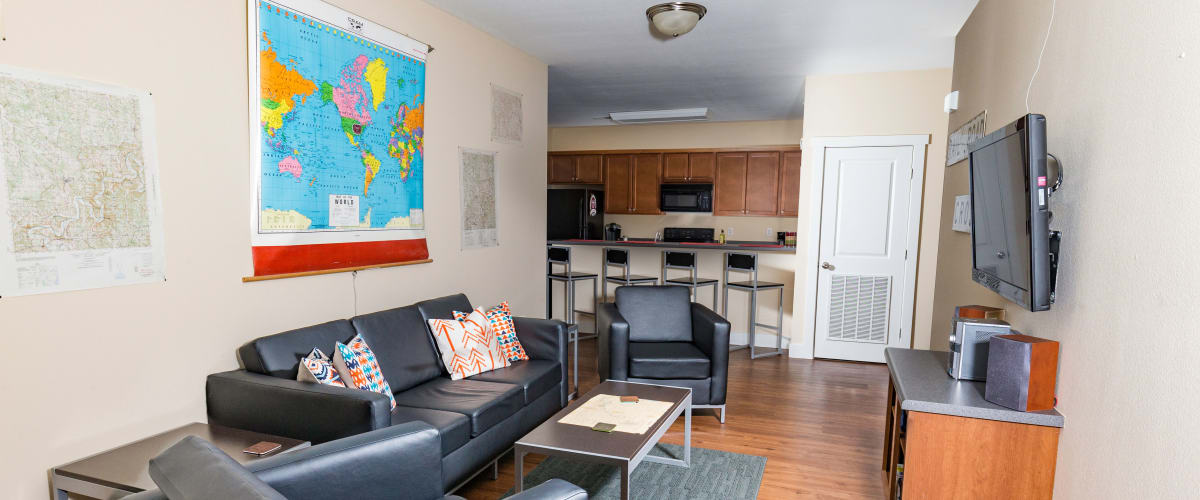 A living room with wood-style flooring at Beacon Springfield in Springfield, Missouri