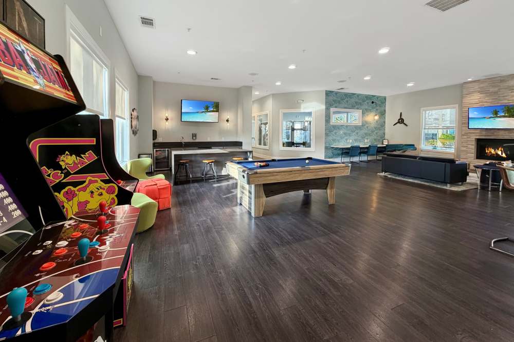 Lounge area with billiards table and arcade games at Avion Apartments in Rancho Cordova, California